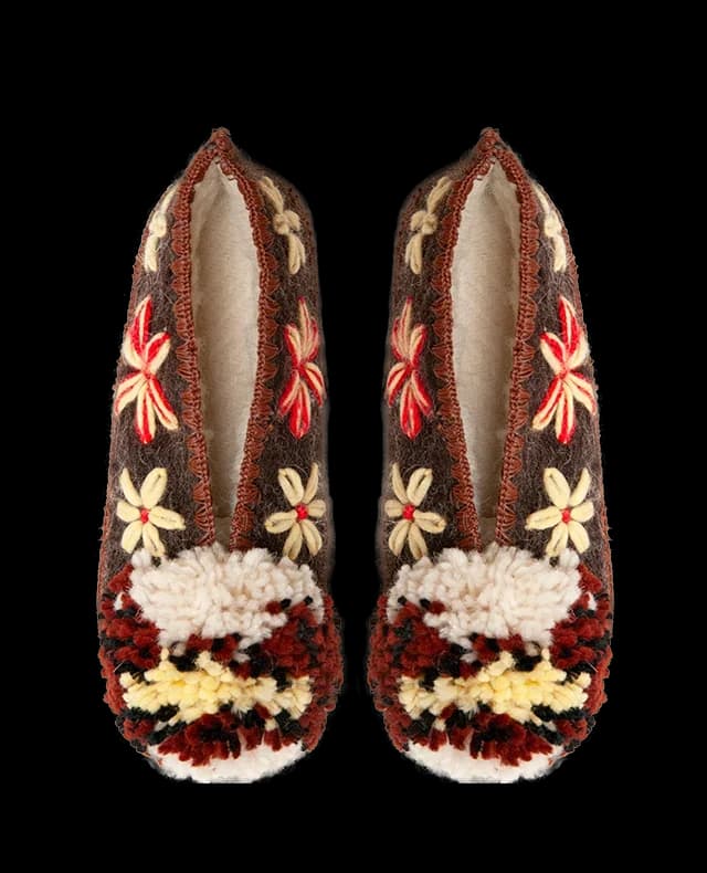 A pair of Give A Pon woollen slippers with flowers and pompoms